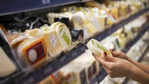 Woman buying cheese ina supermarket Woman buying cheese ina supermarket